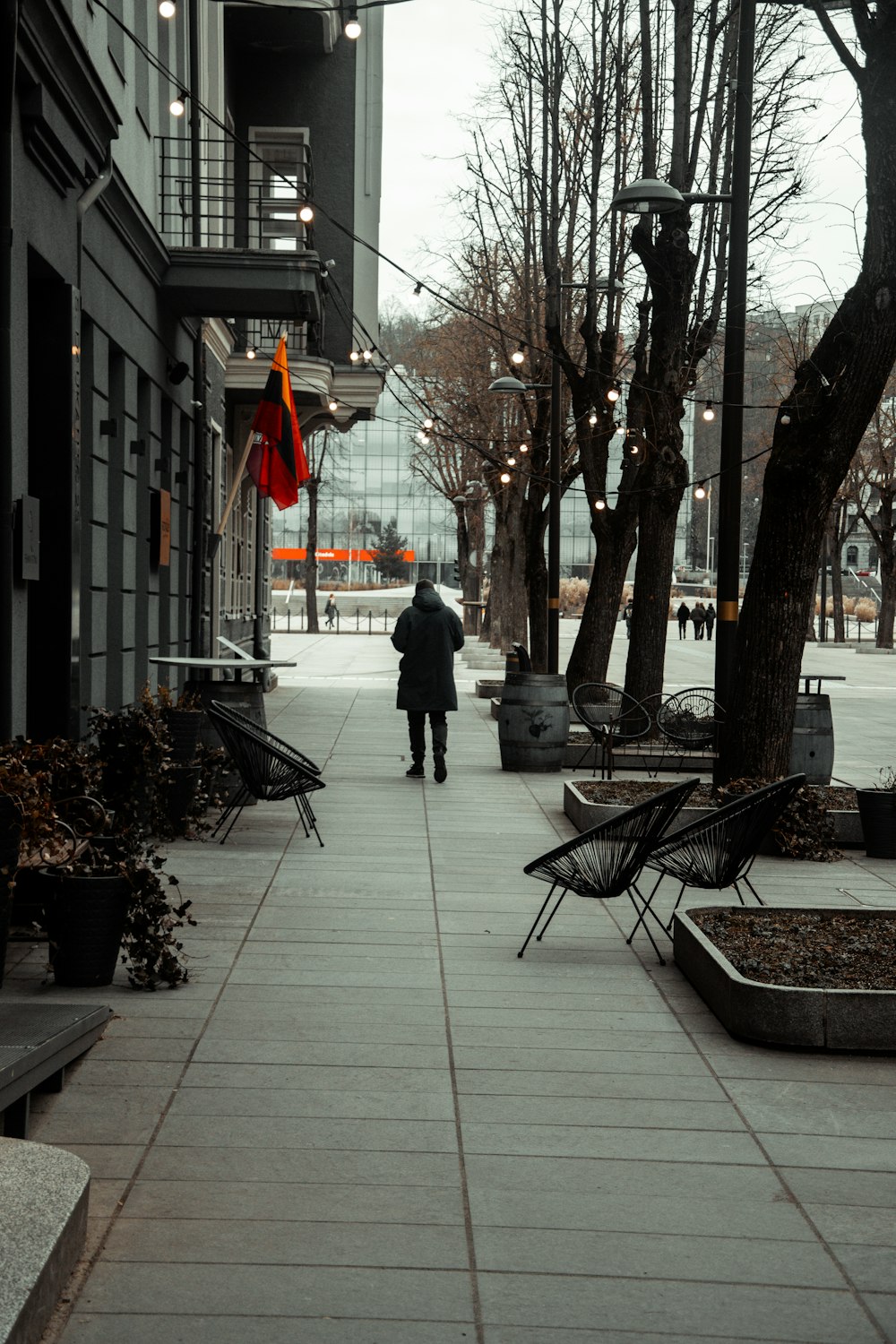 a person walking down a sidewalk in the rain