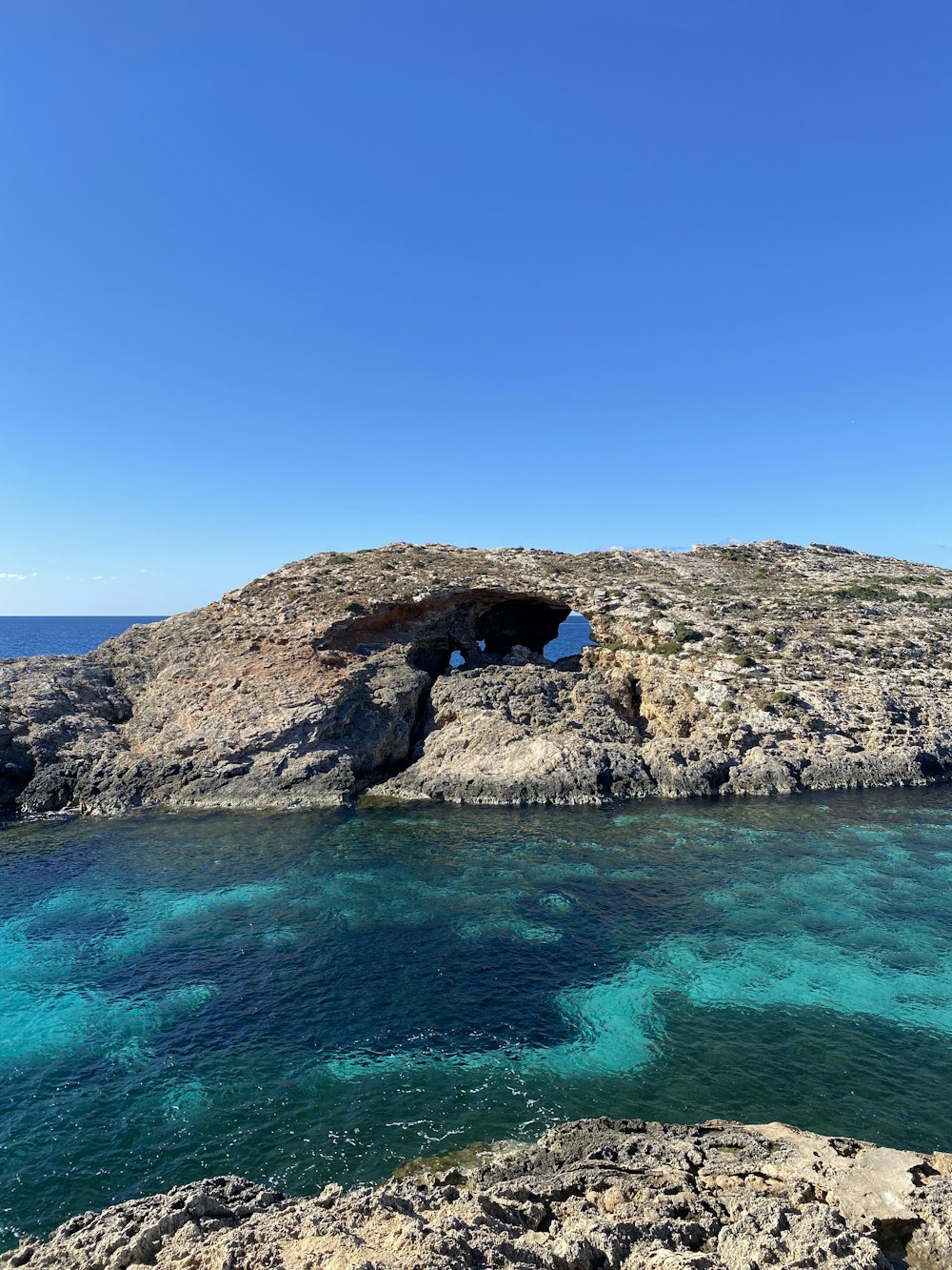 a rock outcropping in the middle of a body of water