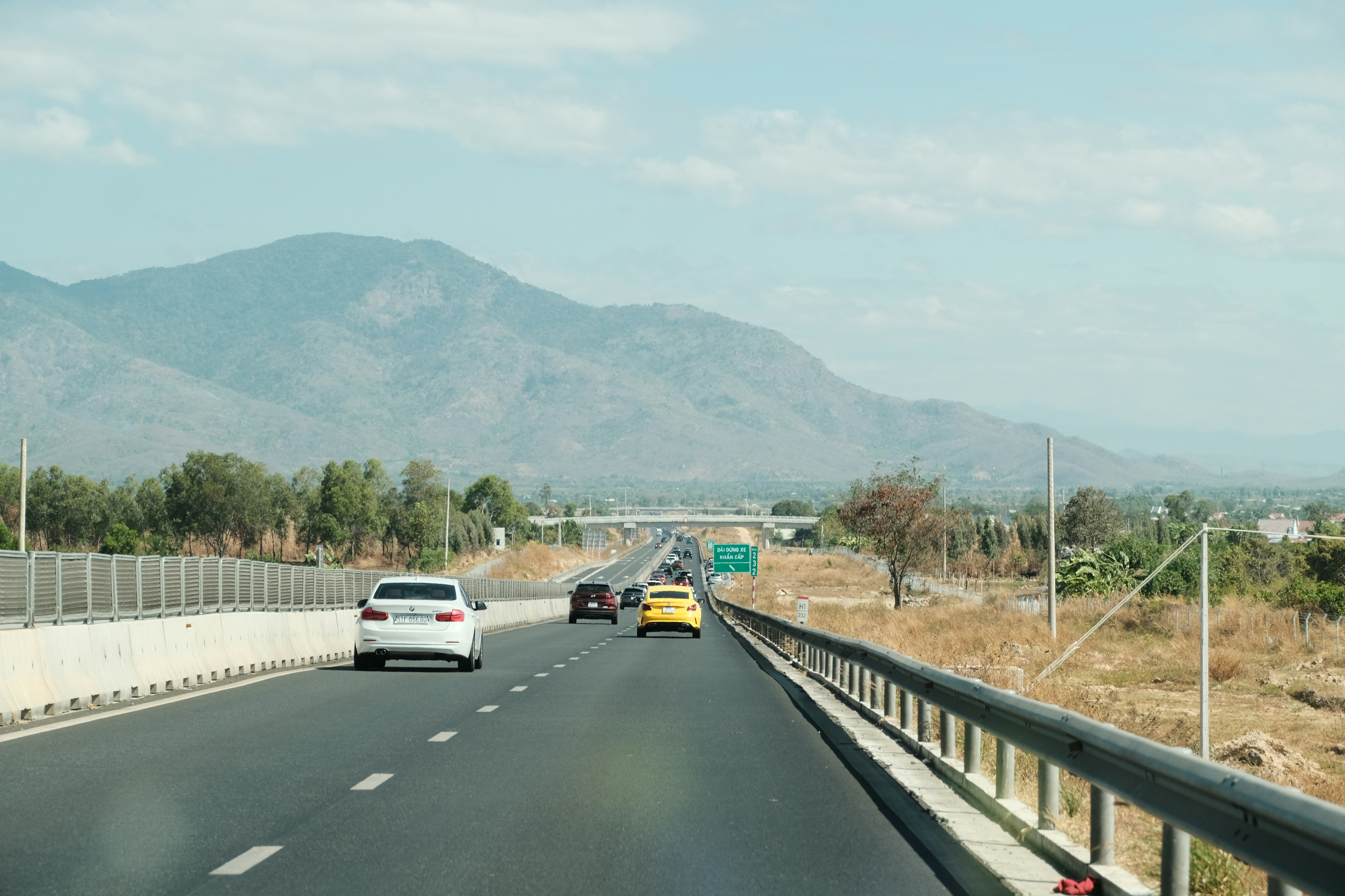 a car driving down a highway with mountains in the background