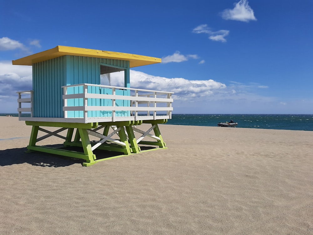 a lifeguard stand on the beach with a boat in the background