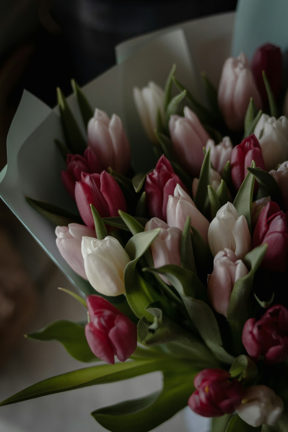 a bouquet of tulips in a vase on a table