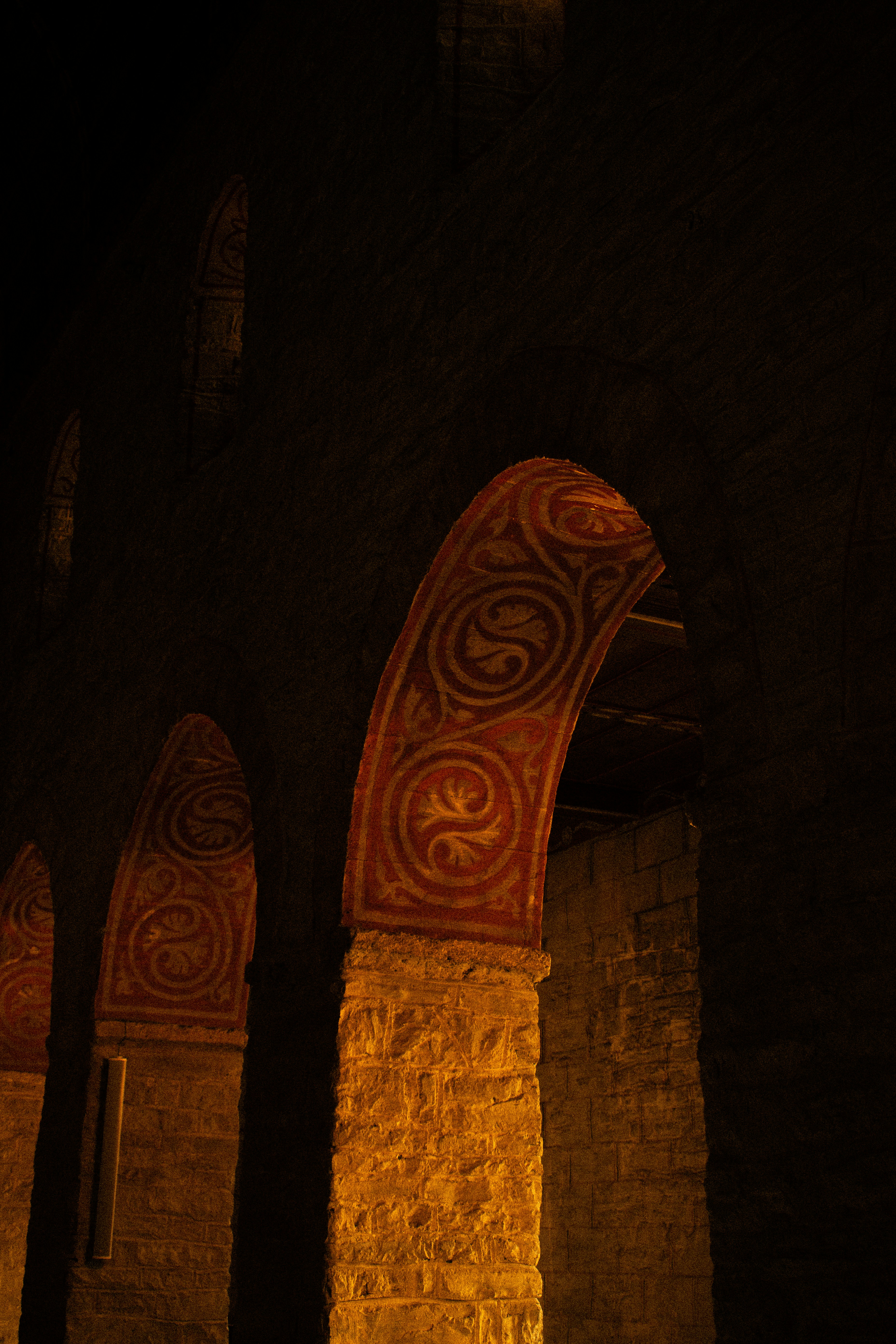 an arch in a stone building with a clock on it