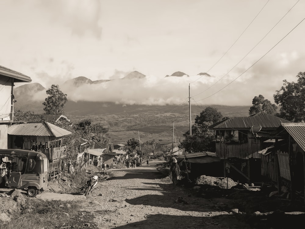 a black and white photo of a village with mountains in the background