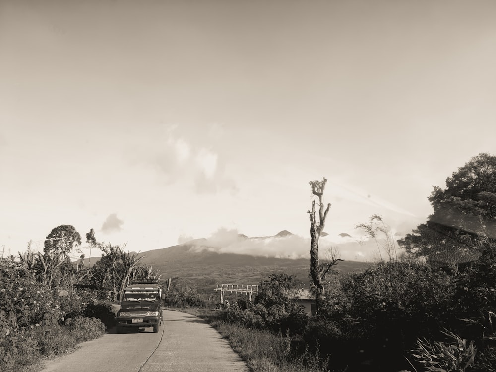 a black and white photo of a truck driving down a road