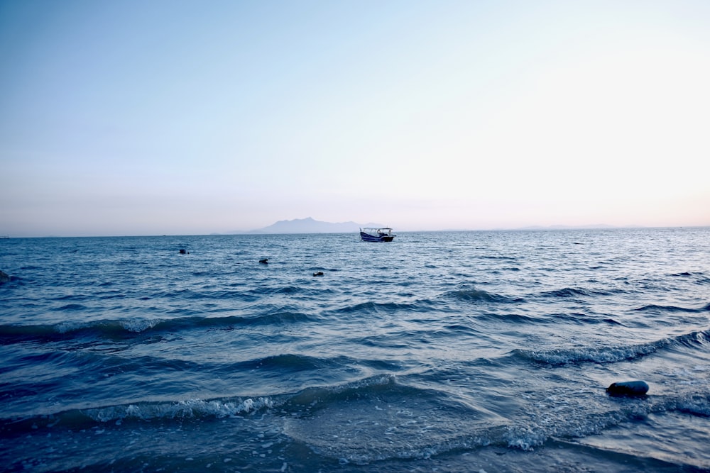 a couple of boats floating on top of a large body of water