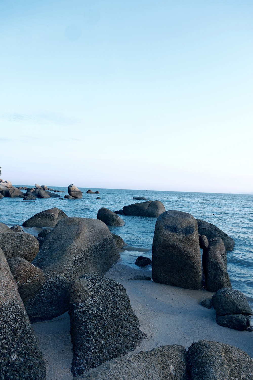 a rocky beach with large rocks in the water