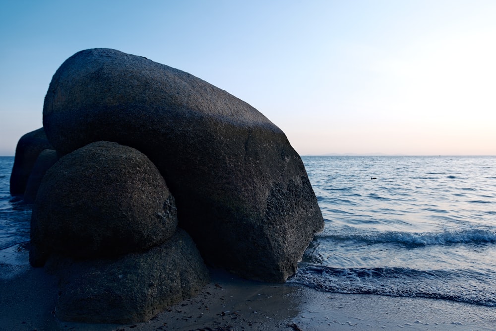 a large rock sitting on top of a sandy beach