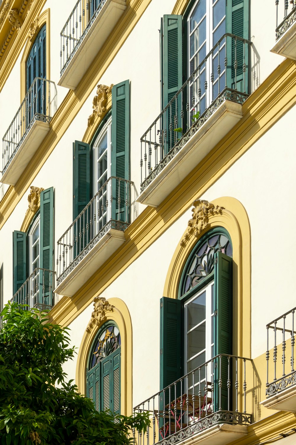 a building with green shutters and balconies