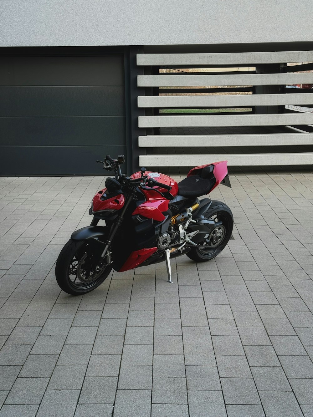 a red and black motorcycle parked in front of a building