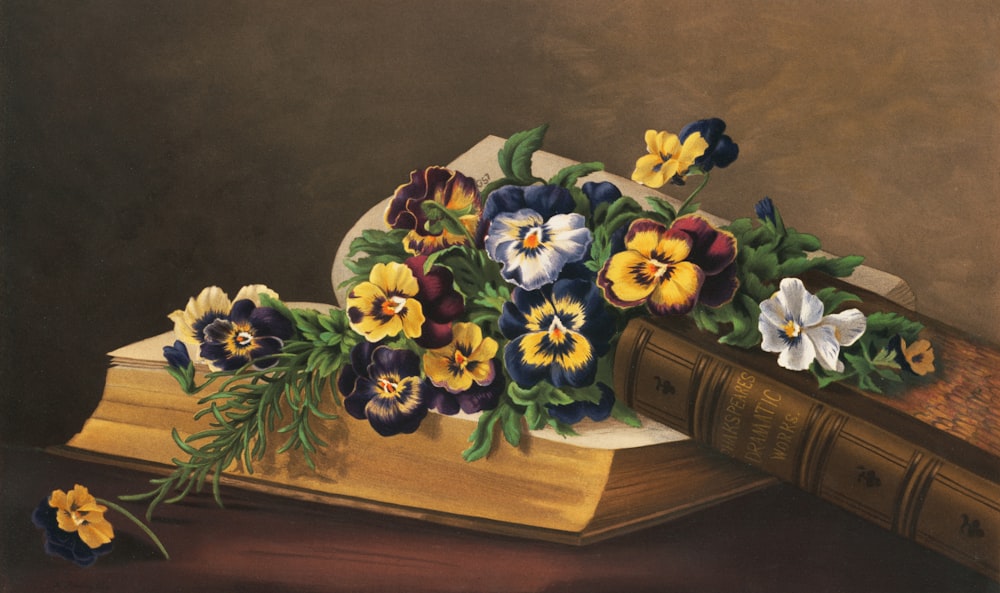 a painting of a book with flowers on top of it