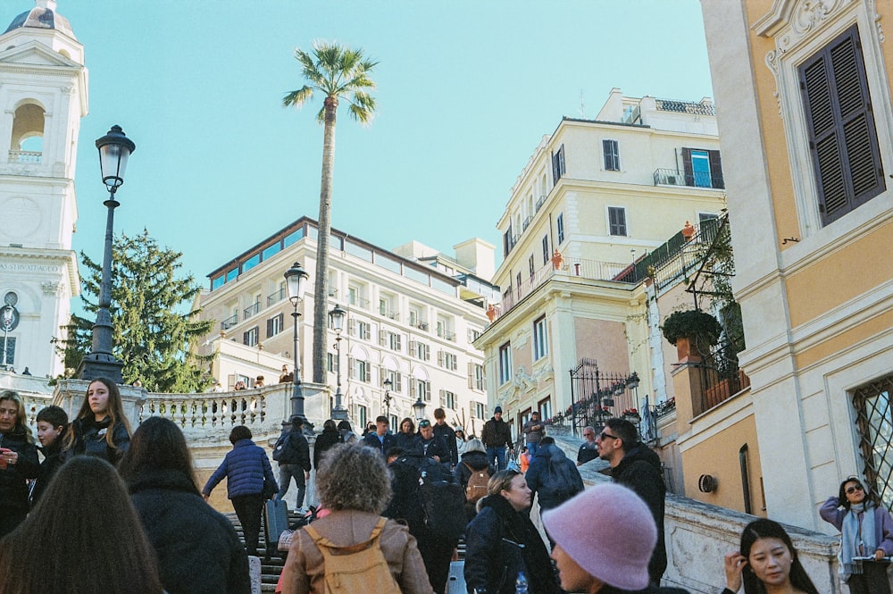 a crowd of people walking down a street next to tall buildings