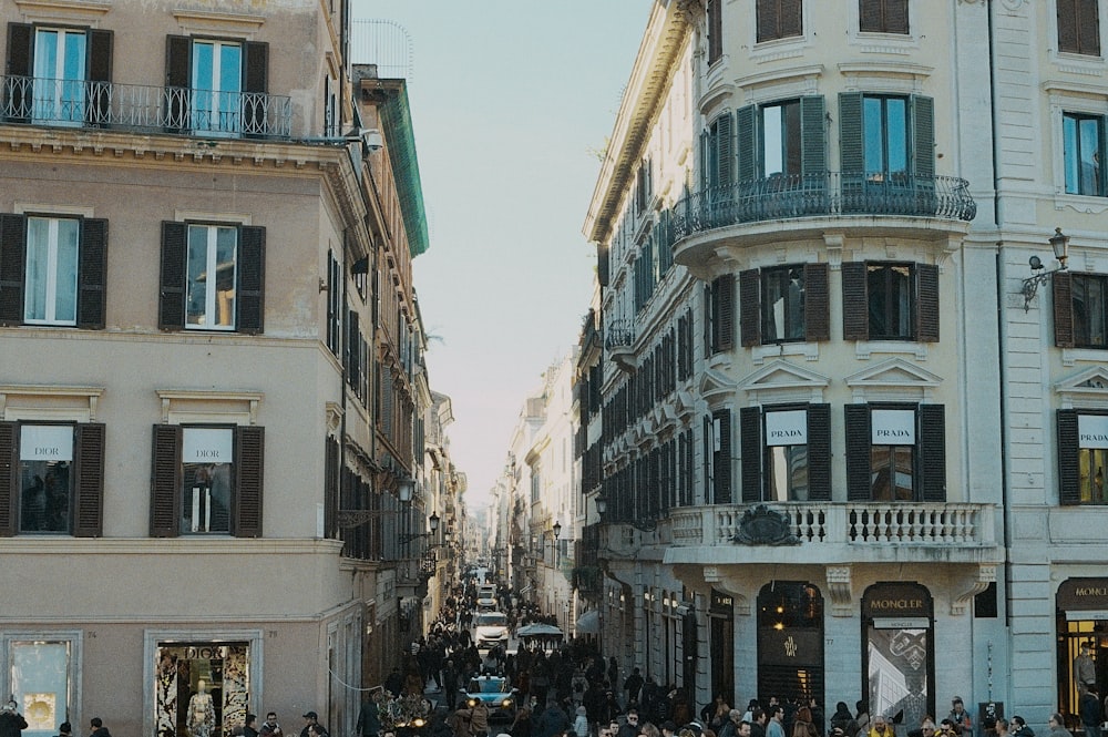 a group of people walking down a street next to tall buildings