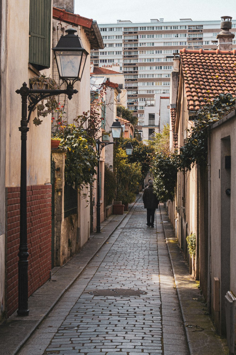 a person walking down a street next to tall buildings