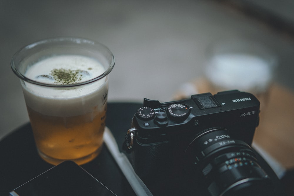 a camera and a glass of beer on a table