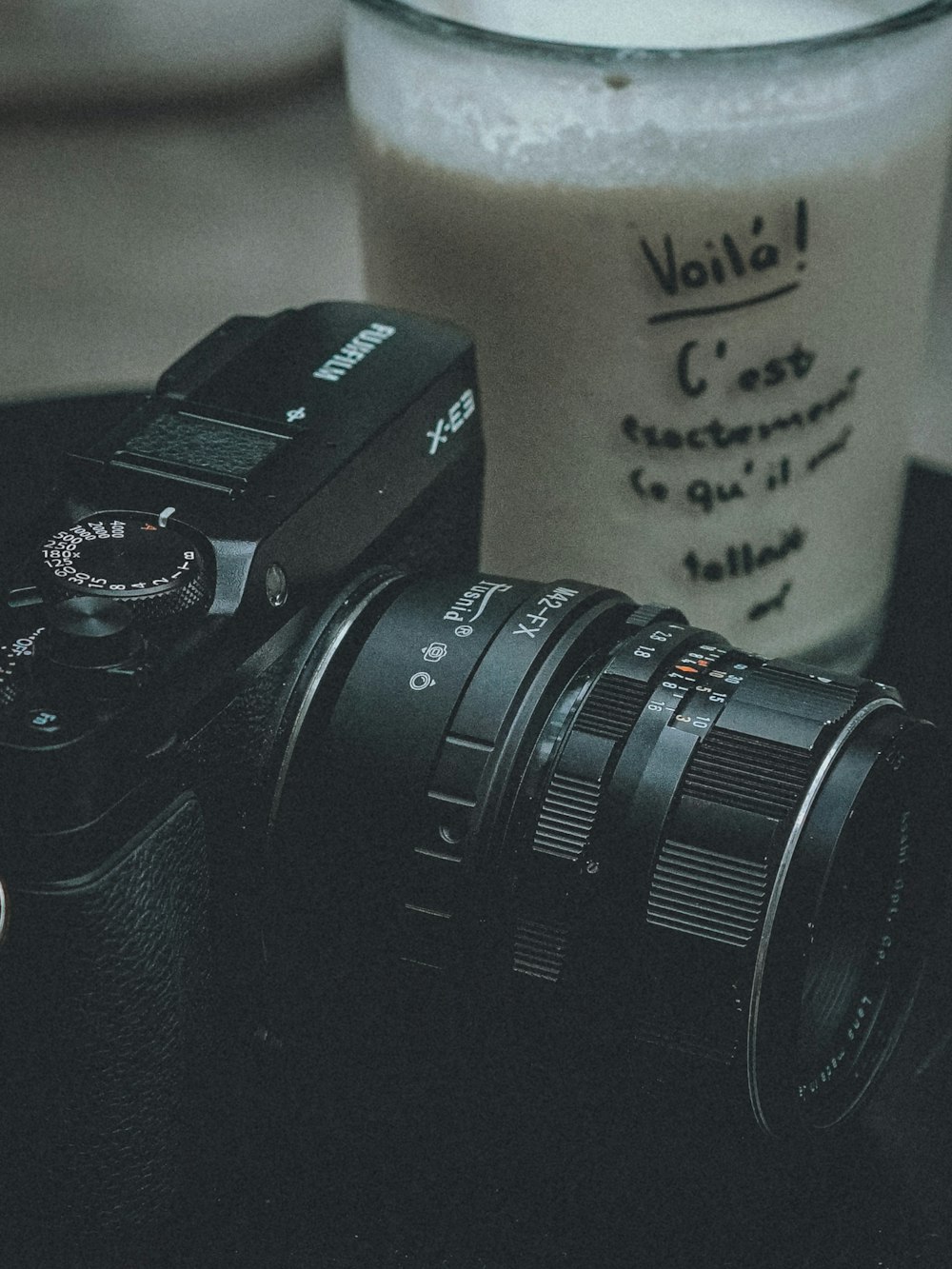 a camera and a glass of milk on a table
