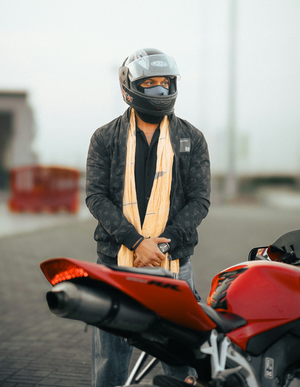 a man standing next to a red motorcycle