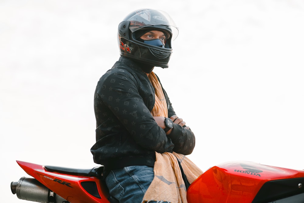 a man sitting on a motorcycle wearing a helmet