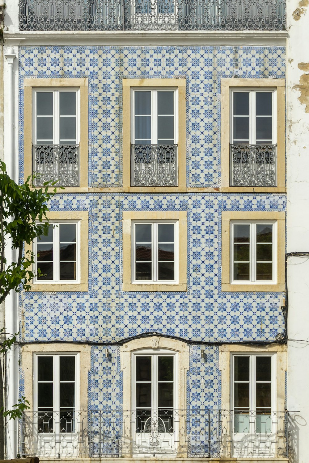 ein blau-weißes Gebäude mit Fenstern und Balkonen