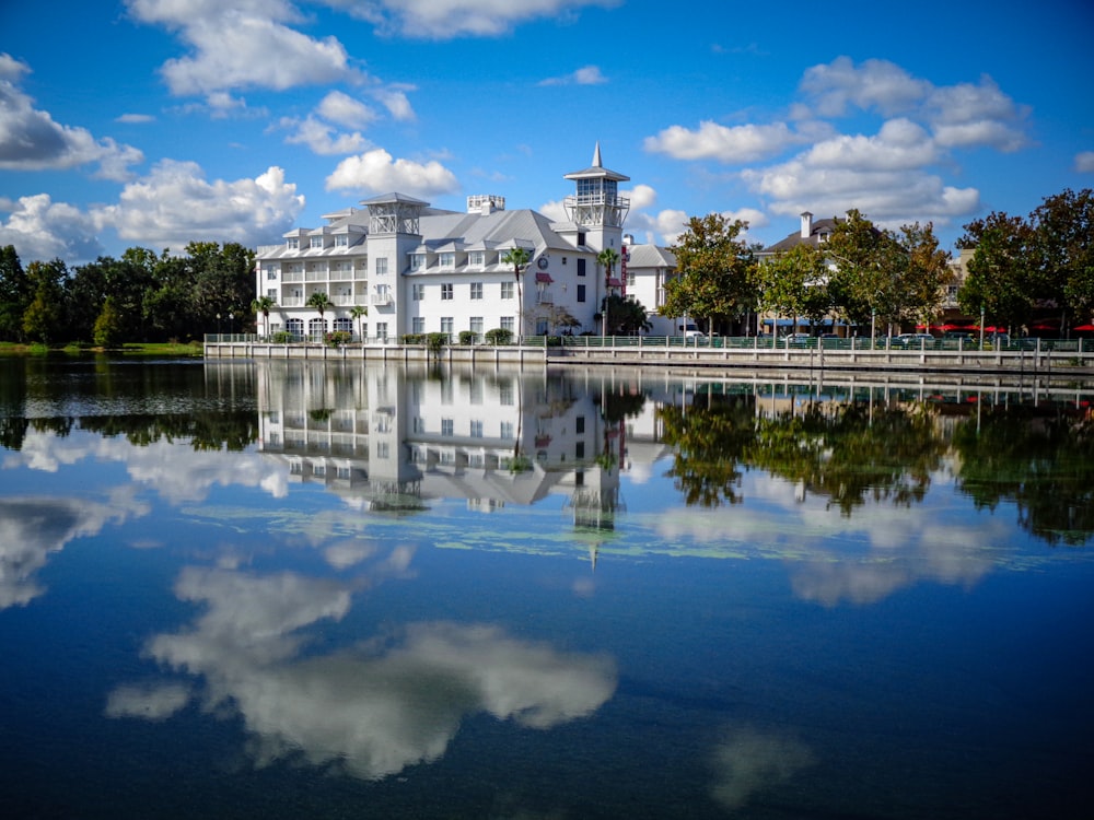 un grande edificio bianco seduto in cima a un lago