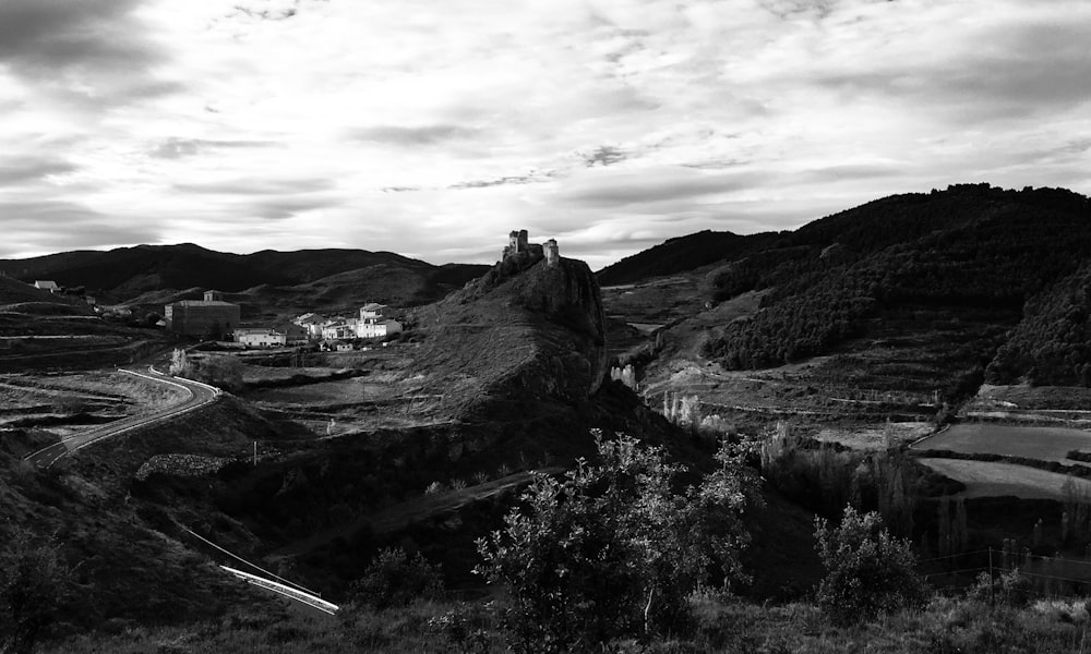 Una foto in bianco e nero di un castello su una collina