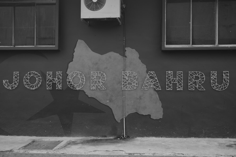 a black and white photo of a wall with a clock