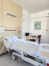 a hospital room with two beds and a desk