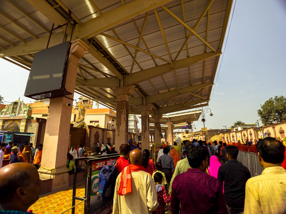 a crowd of people standing under a covered area