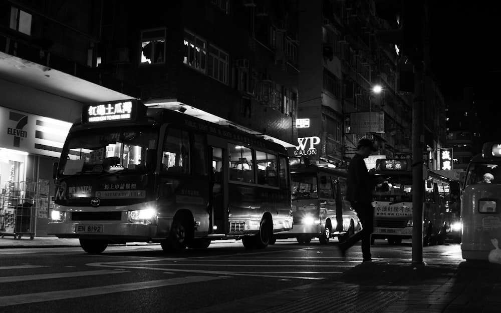 a black and white photo of a bus at night