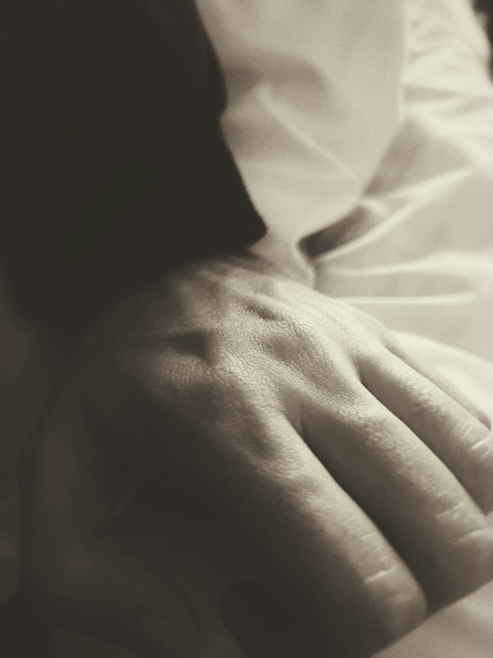 a close up of a person's hand on a bed