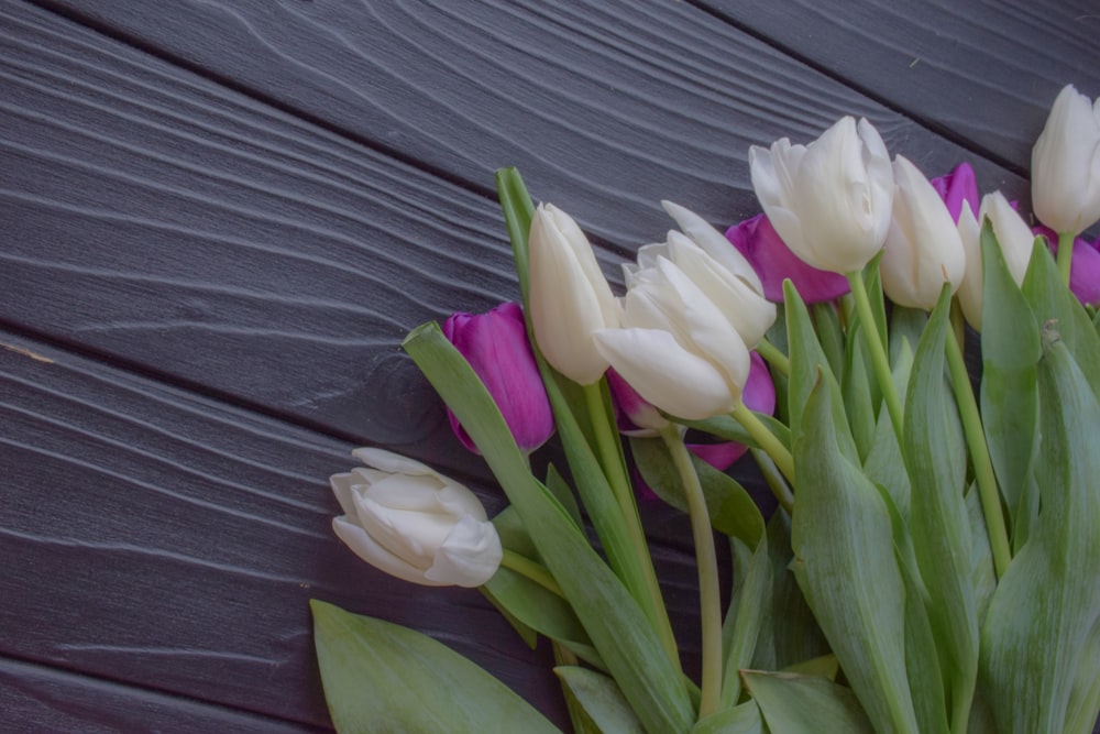 a bouquet of white and purple tulips on a table