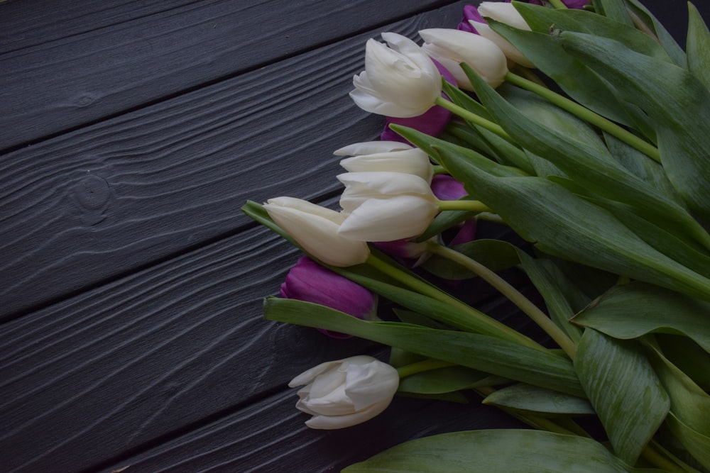 a bouquet of white and purple tulips on a table