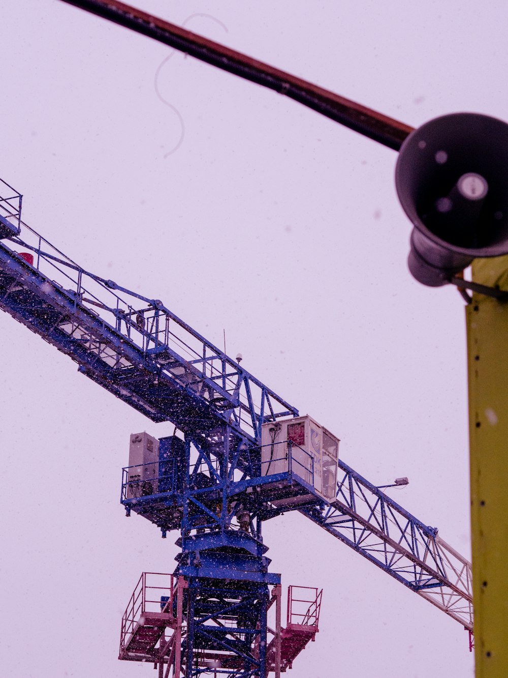 a large crane is sitting on top of a pole