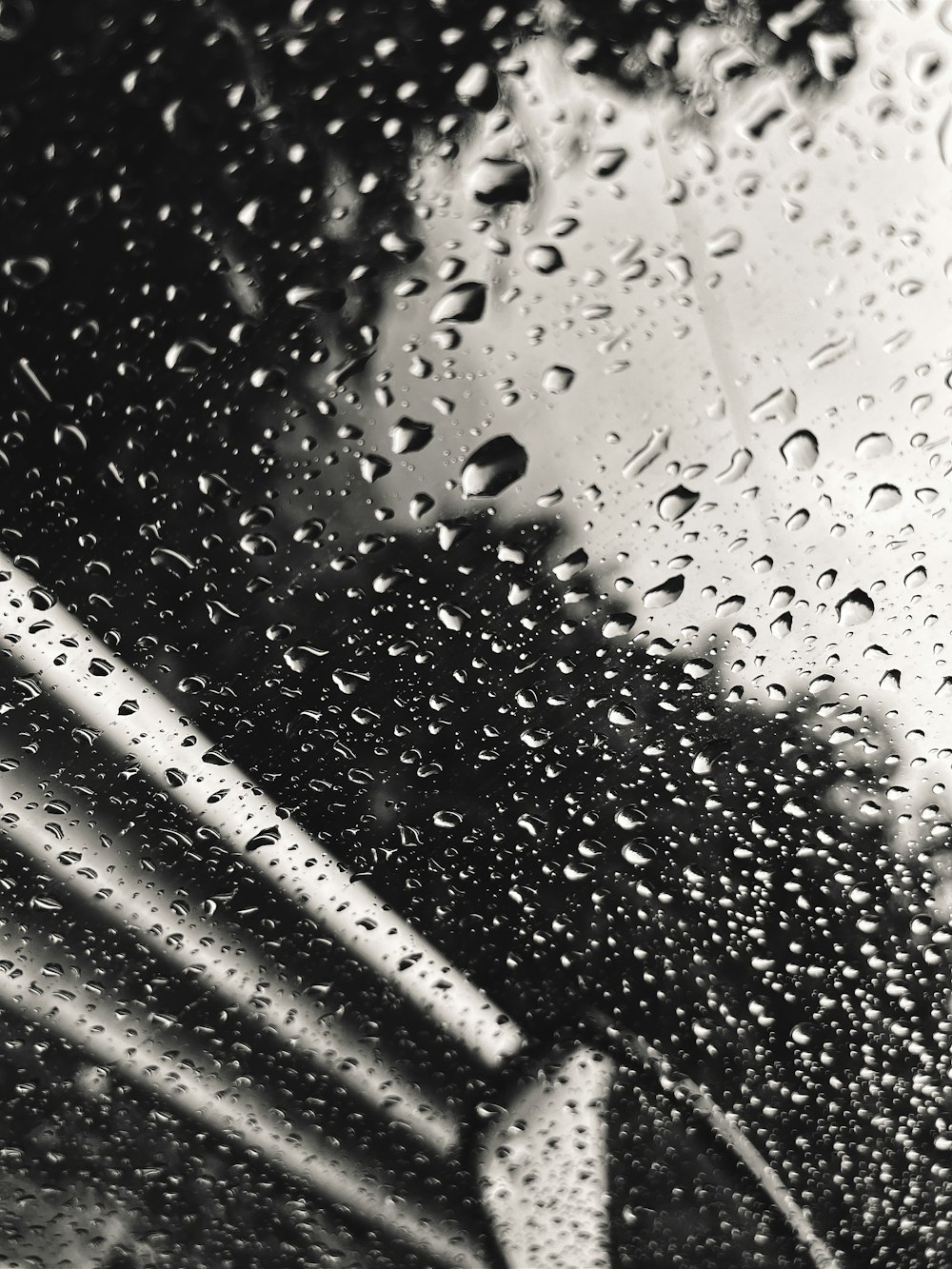 a black and white photo of rain on a window