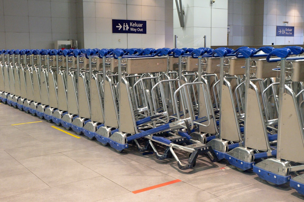 a row of blue and silver luggage carts