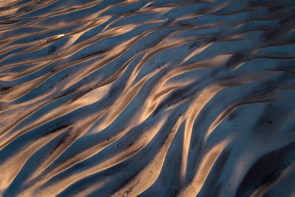 a sandy beach covered in snow at sunset