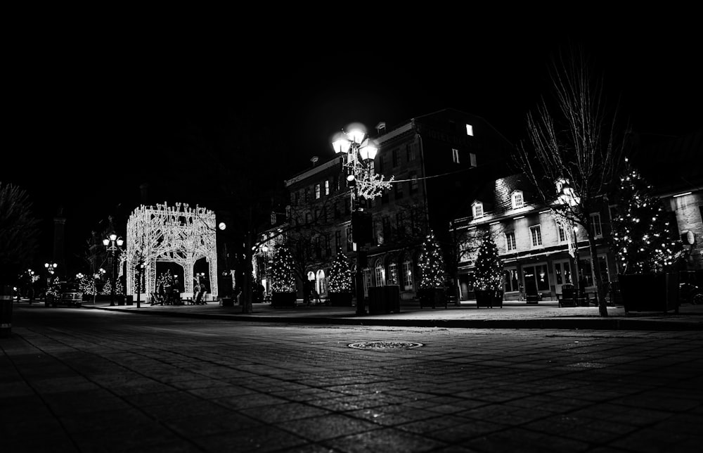 a black and white photo of a street at night