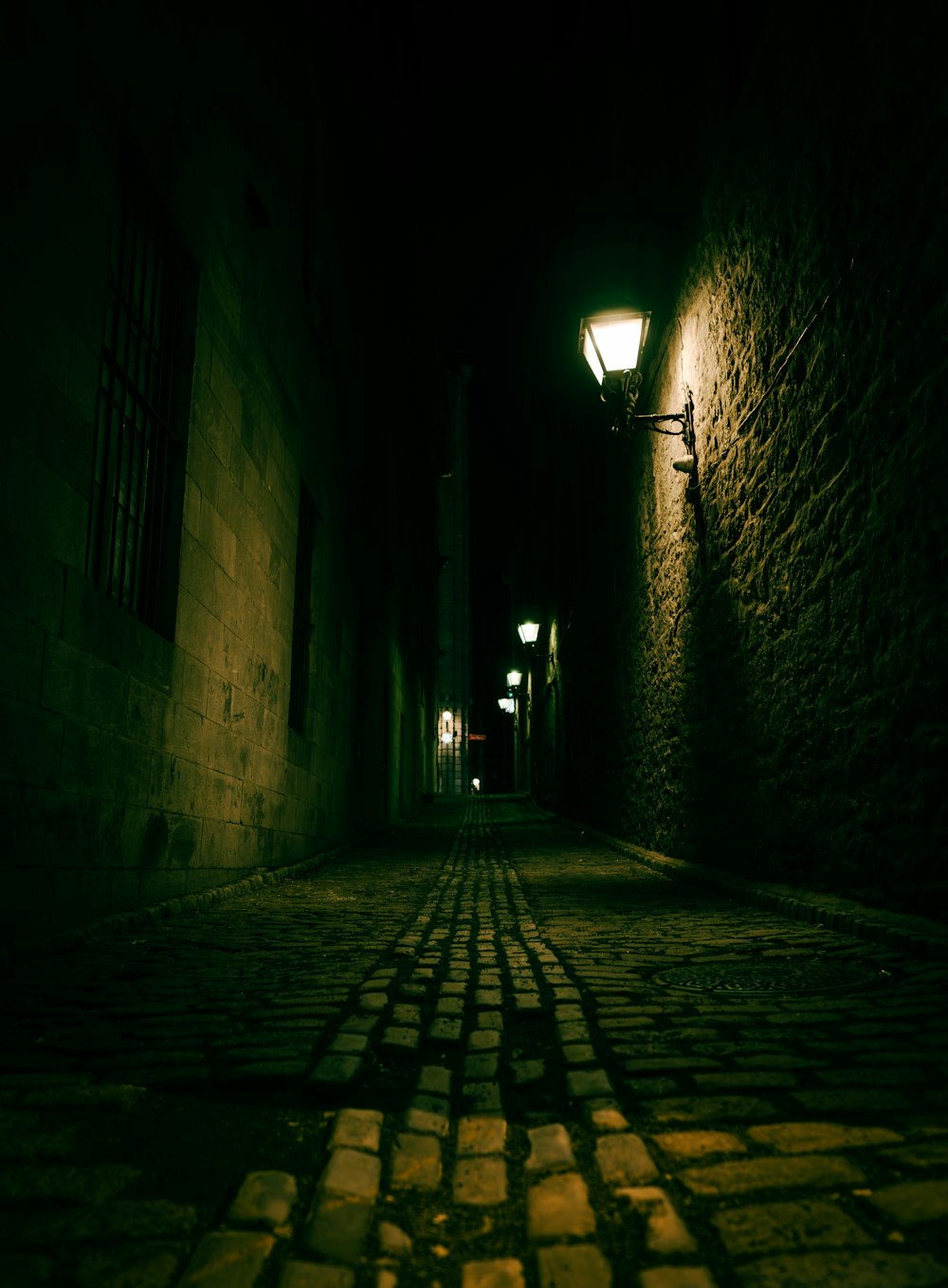 a cobblestone street at night with a street light