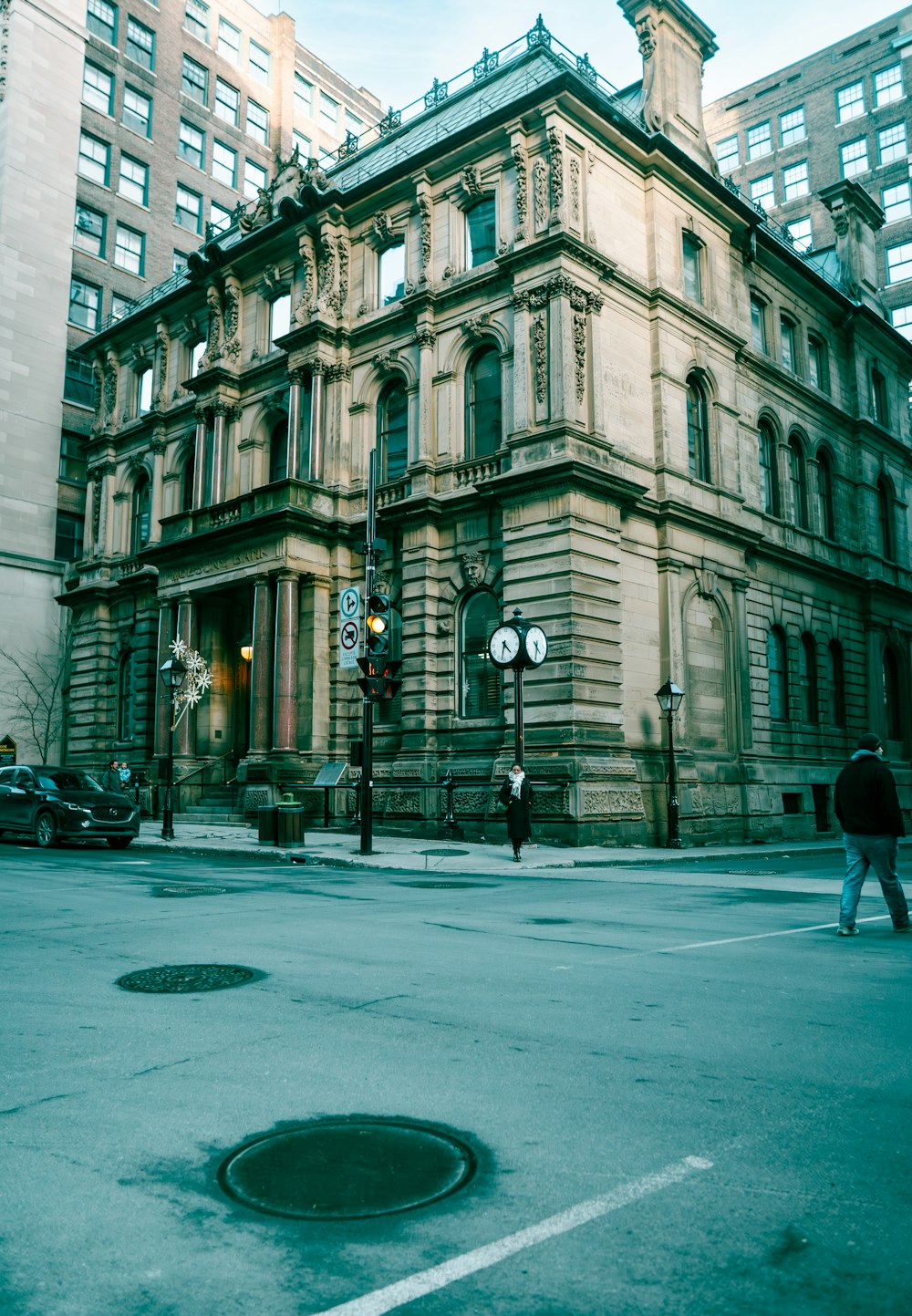 a man walking across a street next to a tall building