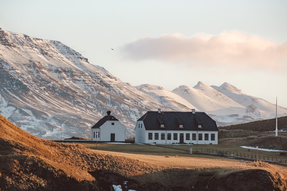 a large white house sitting on top of a lush green hillside