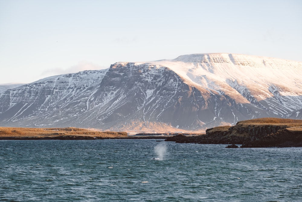 a body of water with a mountain in the background