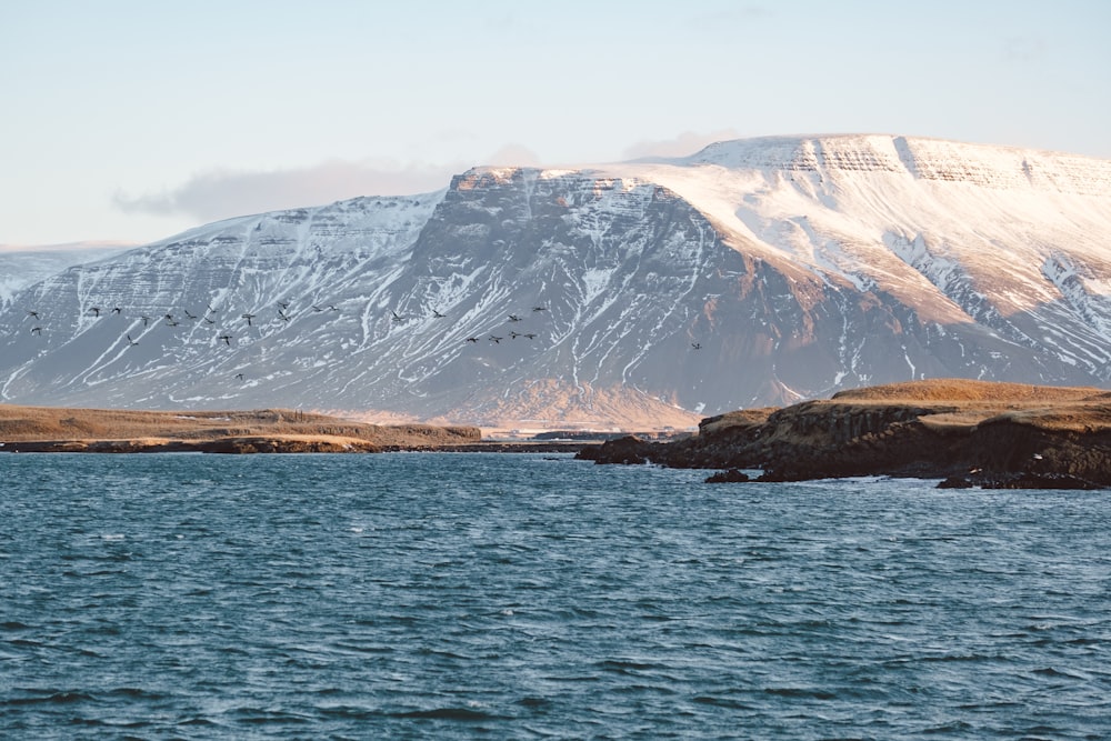 a large body of water with a mountain in the background