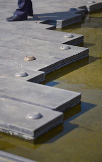 a person standing next to a row of concrete slabs