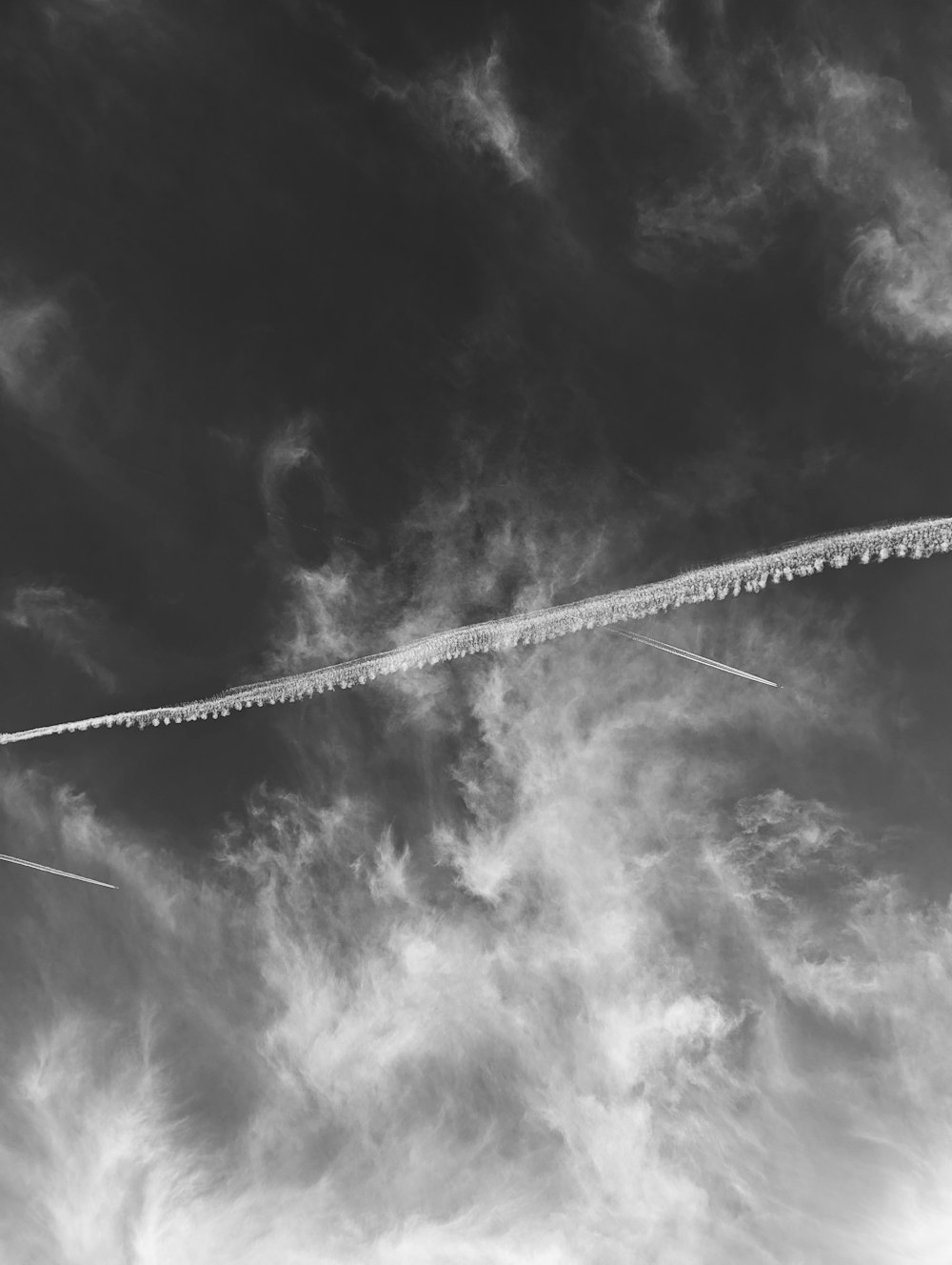 a plane is flying through the cloudy sky