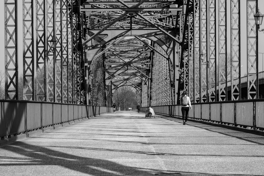 a person walking across a bridge on a sunny day