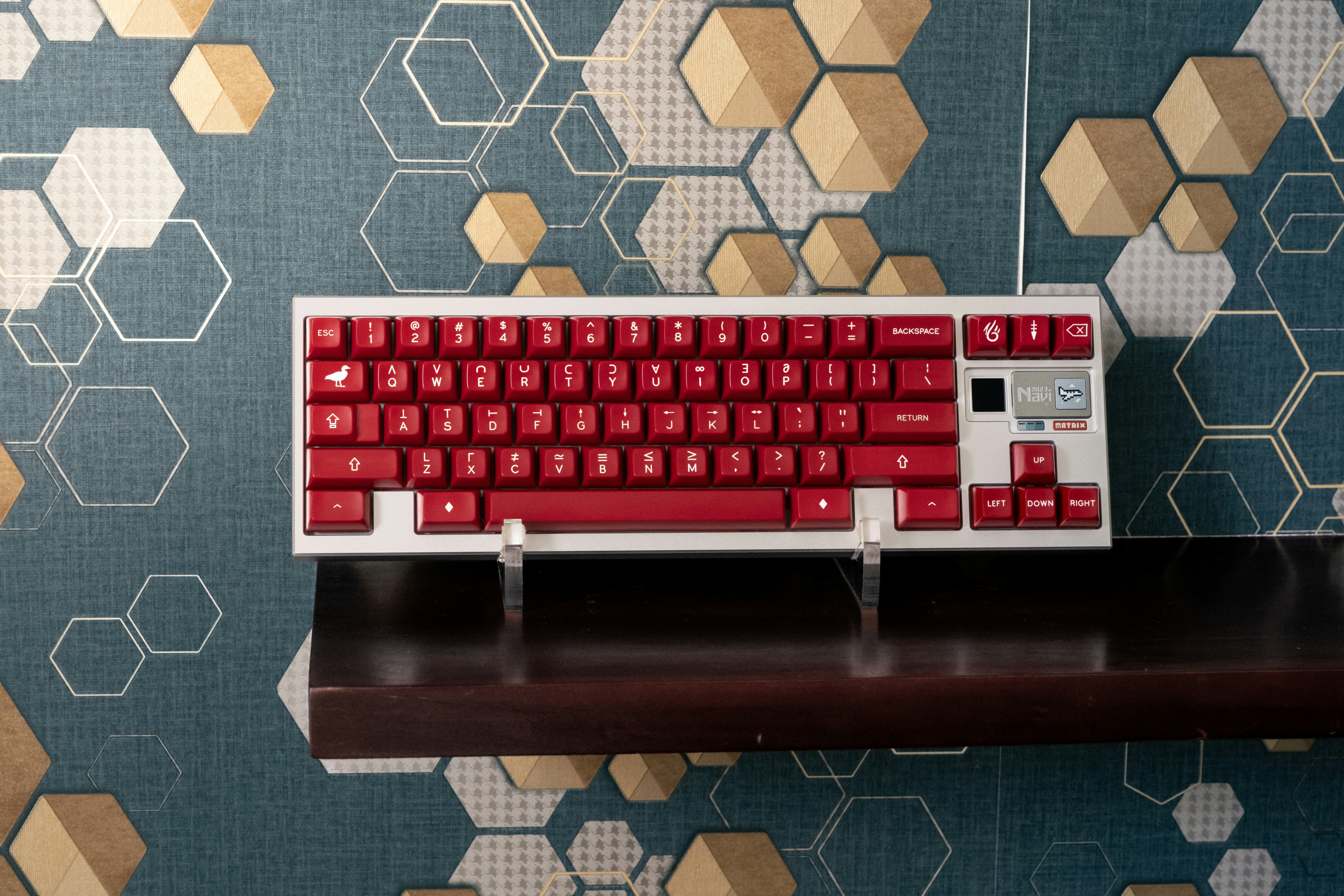 a red keyboard sitting on top of a wooden shelf