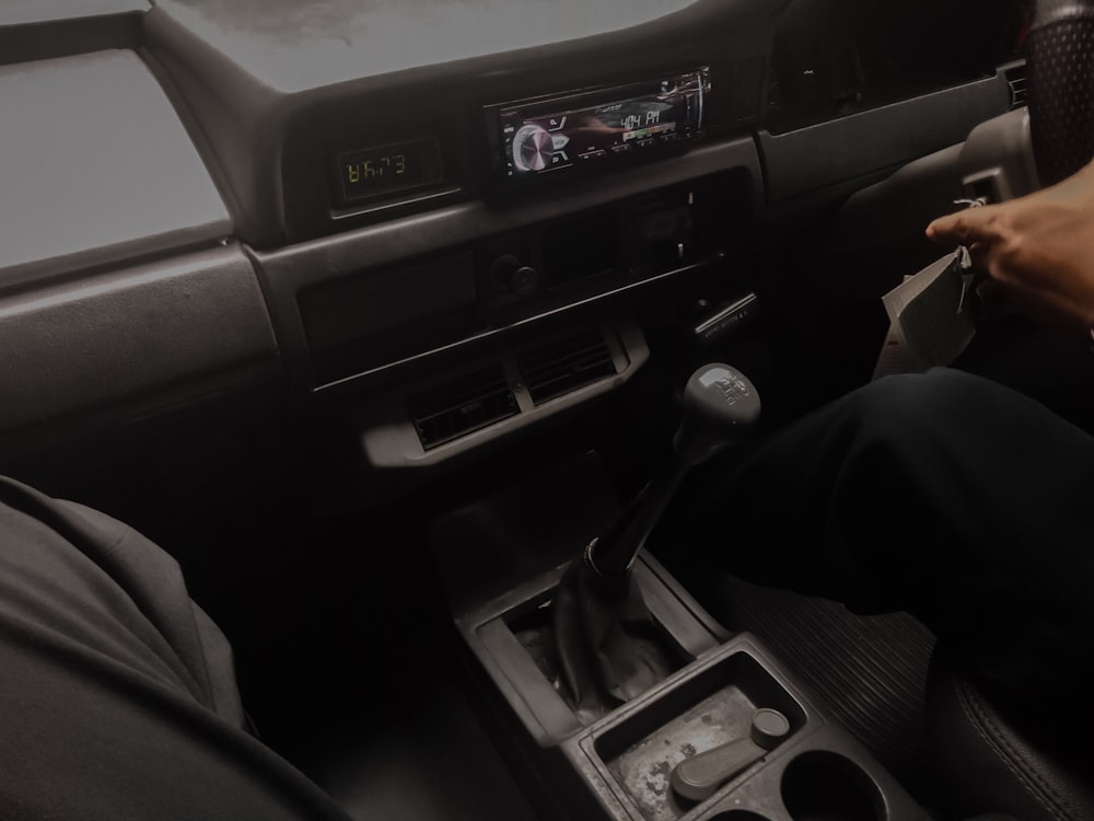 a person sitting in a car with a steering wheel