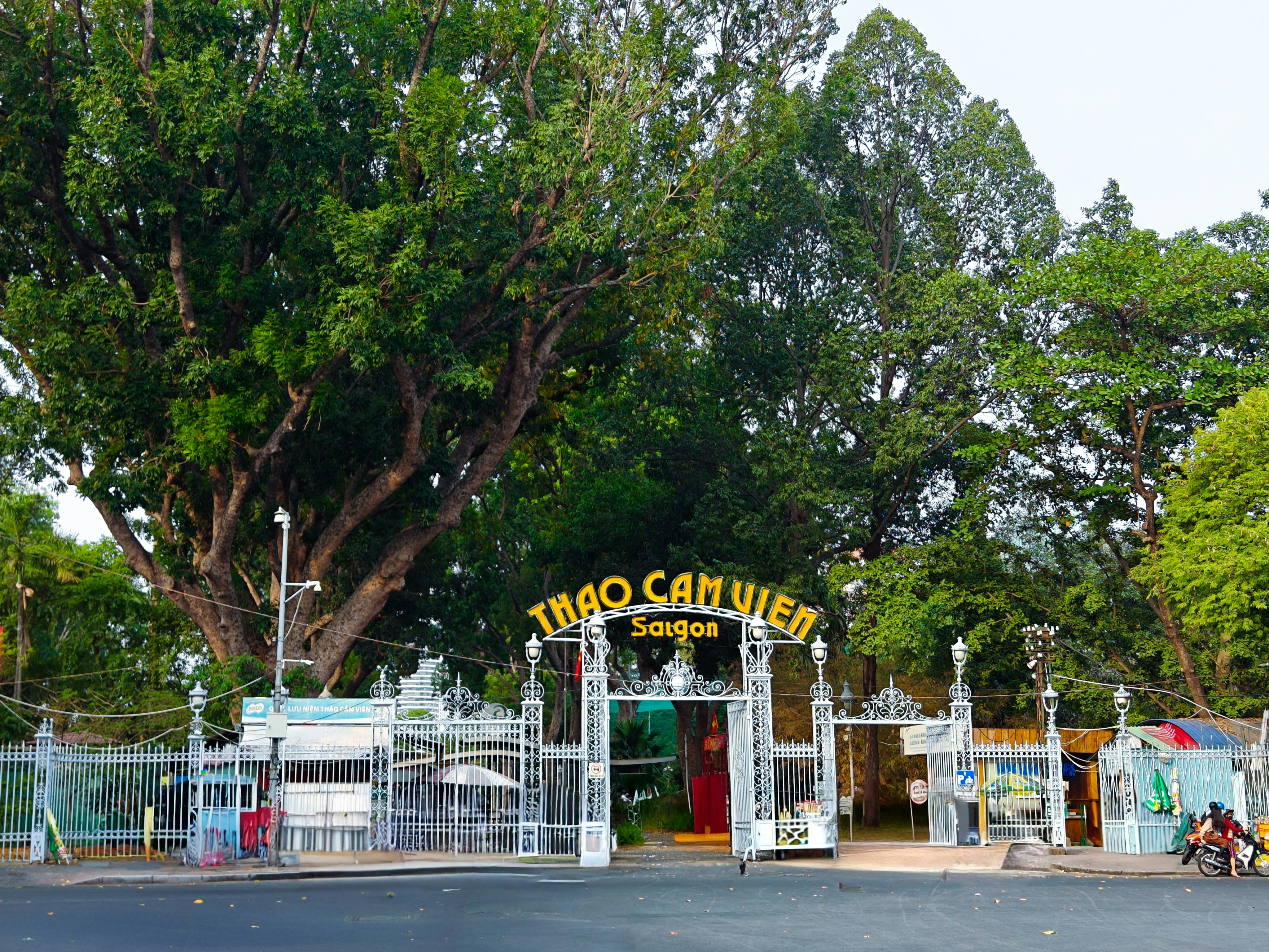 a gated entrance to a park with a motorcycle parked in front of it