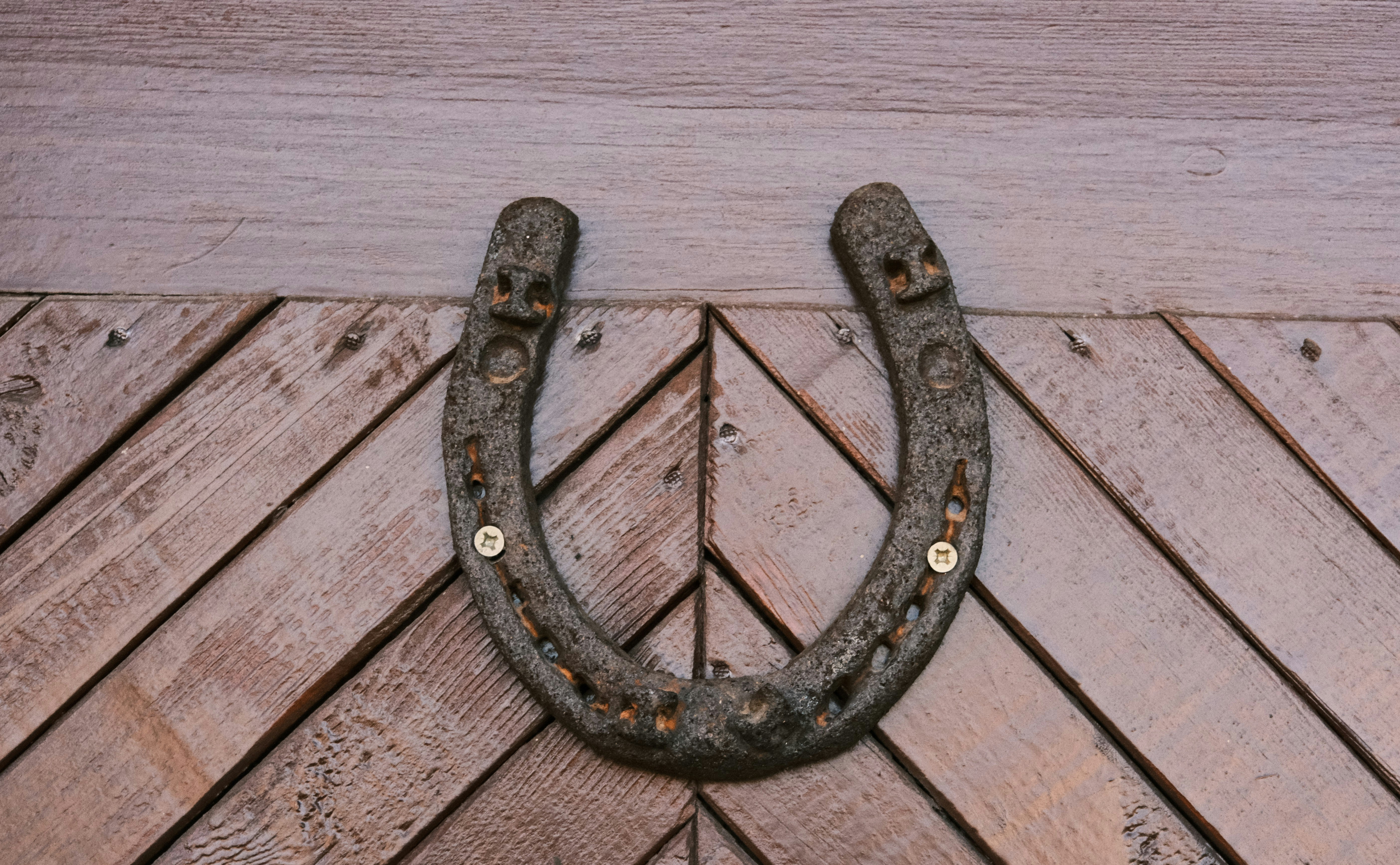 an old metal hook on a wooden wall