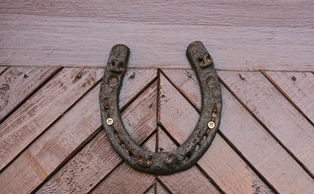 an old metal hook on a wooden wall