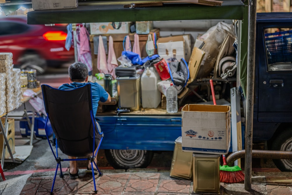 a man sitting in a chair in front of a truck